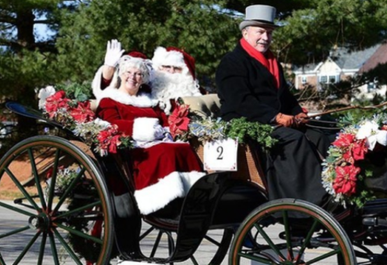 Mr. and Mrs. Claus riding in the back of a carriage